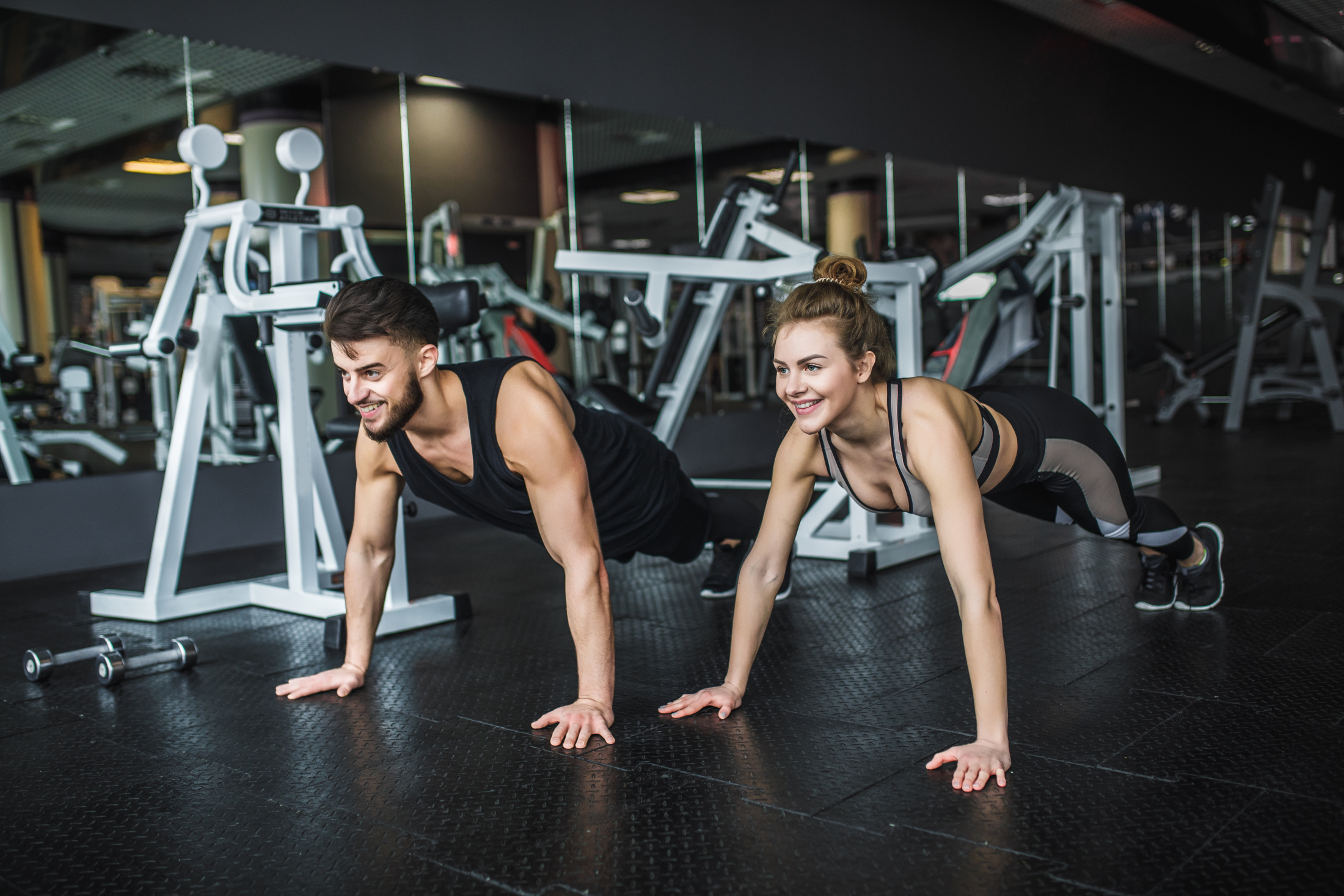 motivated-young-blond-woman-and-man-in-middle-of-workout-standing-in-plank-with-hands-clenched-together.jpg