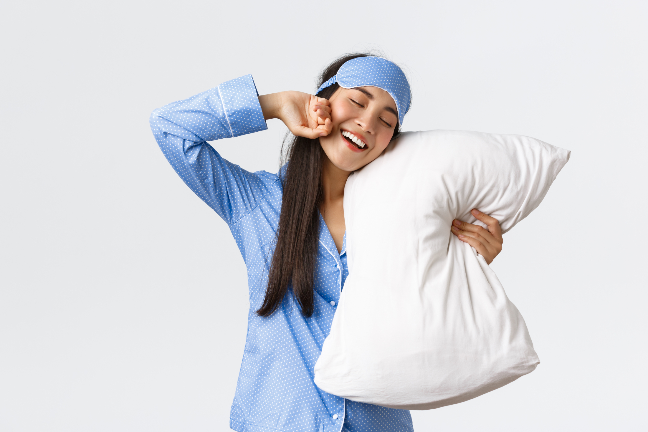 smiling-pleased-cute-asian-girl-in-blue-pyjama-and-sleeping-mask-hugging-pillow-and-stretching-hands-delighted-as-finally-going-bed-want-sleep-or-waking-up-in-morning-white-background.jpg
