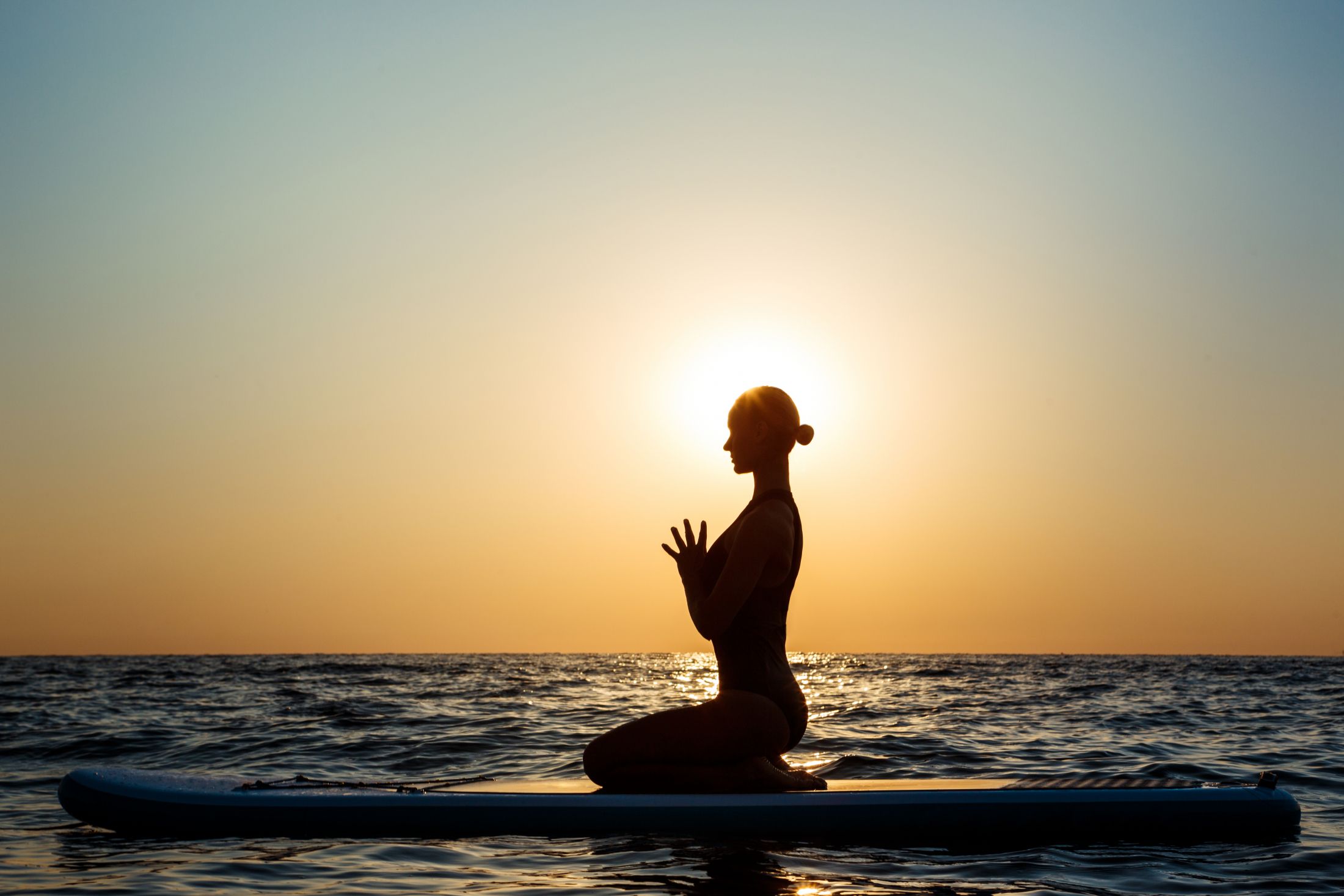 silhouette-beautiful-woman-practicing-yoga-surfboard-sunrise.jpg