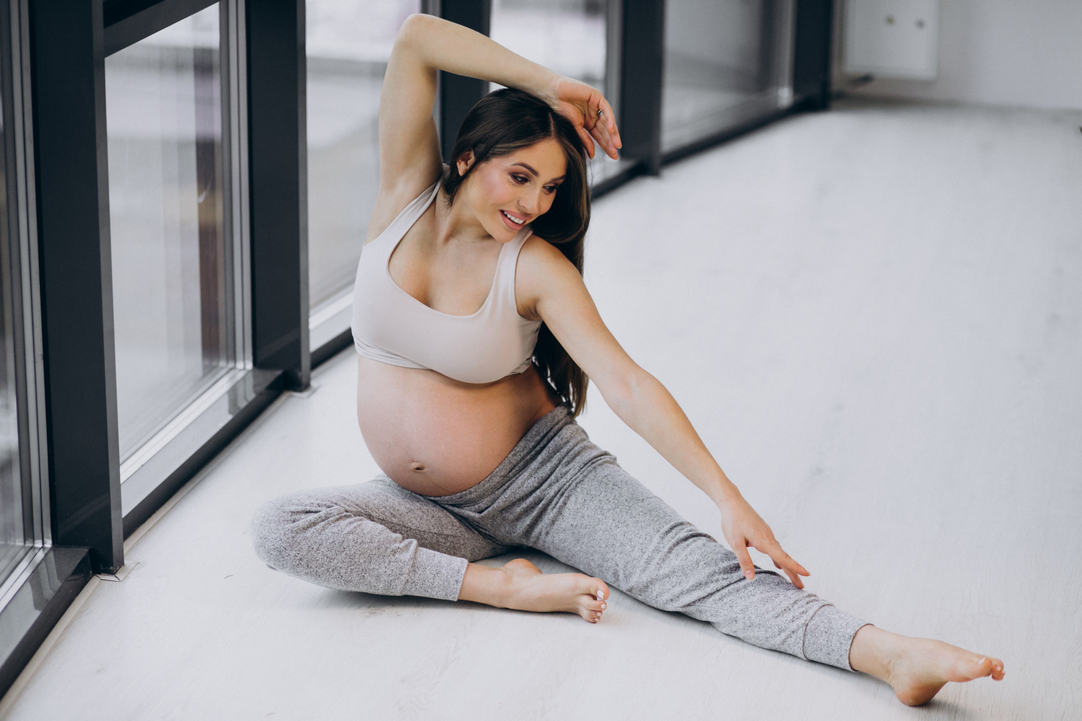 pregnant-woman-practising-yoga-at-home-by-the-window.jpg