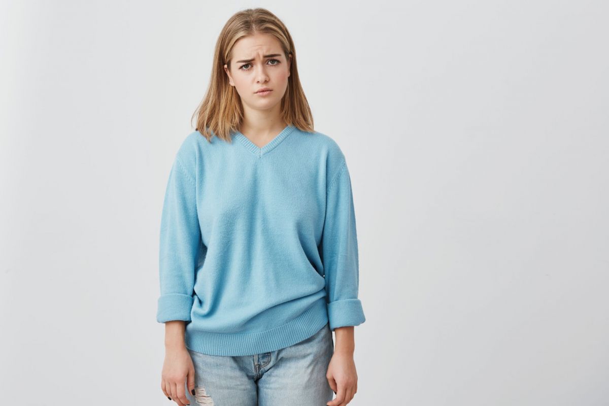 sad-unhappy-beautiful-woman-with-straight-fair-hair-having-dark-charming-eyes-posing-at-studio-upset-because-of-bad-news-pretty-girl-in-blue-sweater-and-jeans.jpg