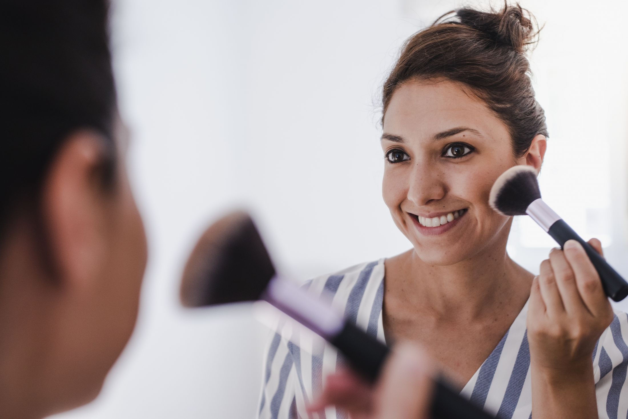 young-female-putting-on-makeup-in-front-of-the-mirror.jpg