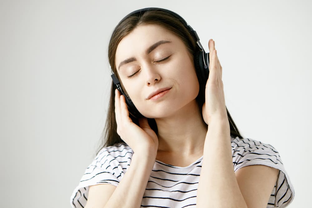 brunette-student-woman-posing-with-eyes-closed-listening-to-calm-meditative-sounds-of-nature-or-ambient-tracks-using-headphones (1).jpg