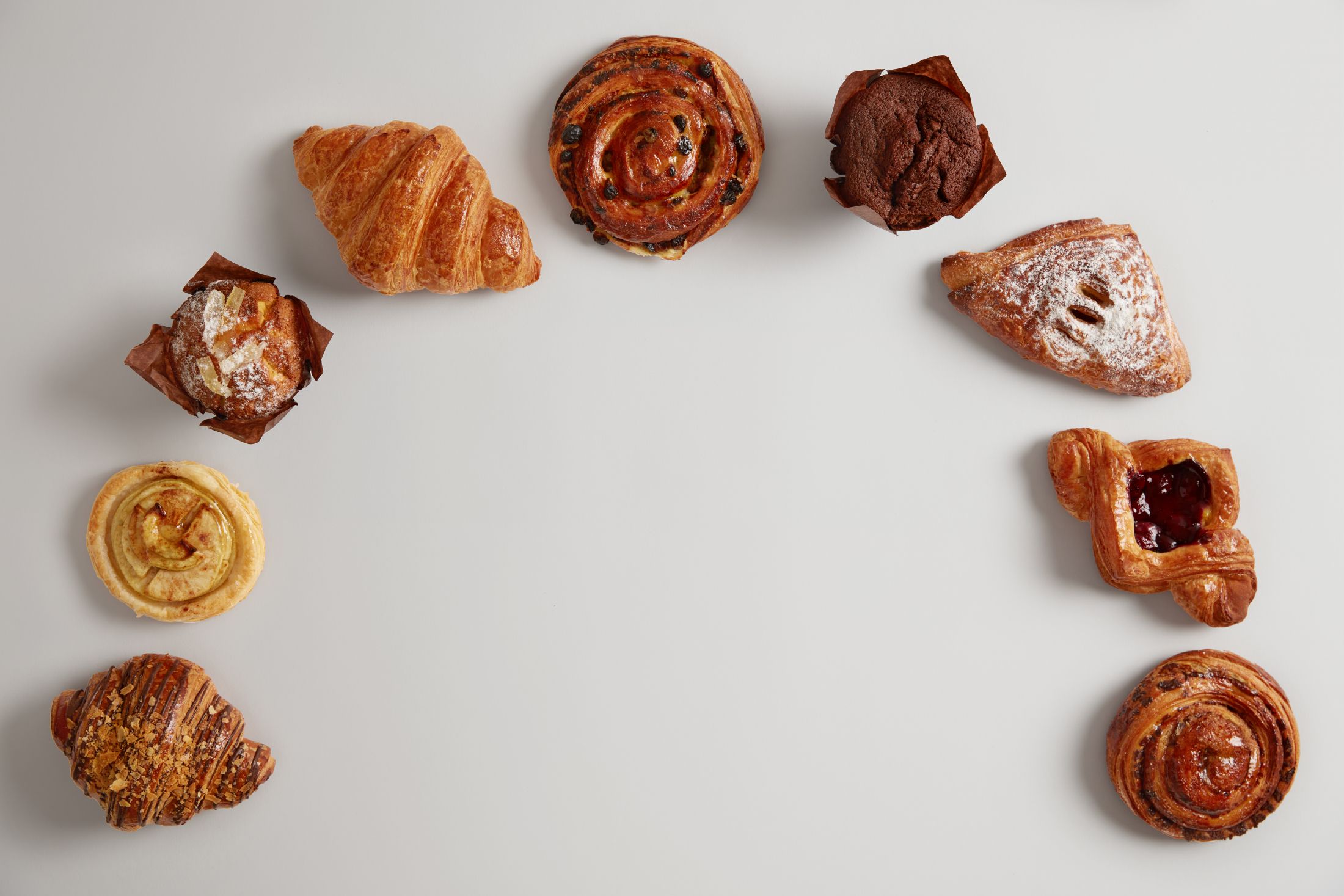 bakery-foodstuff-set-big-variety-of-delicious-confectionery-in-half-circle-on-white-background-croissant-muffin-swirls-and-buns-for-eating-yummy-dessert-sweet-food-and-unhealthy-nutrition.jpg