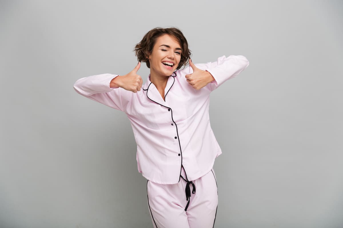 portrait-of-a-cheerful-girl-in-pajamas-showing-thumbs-up.jpg