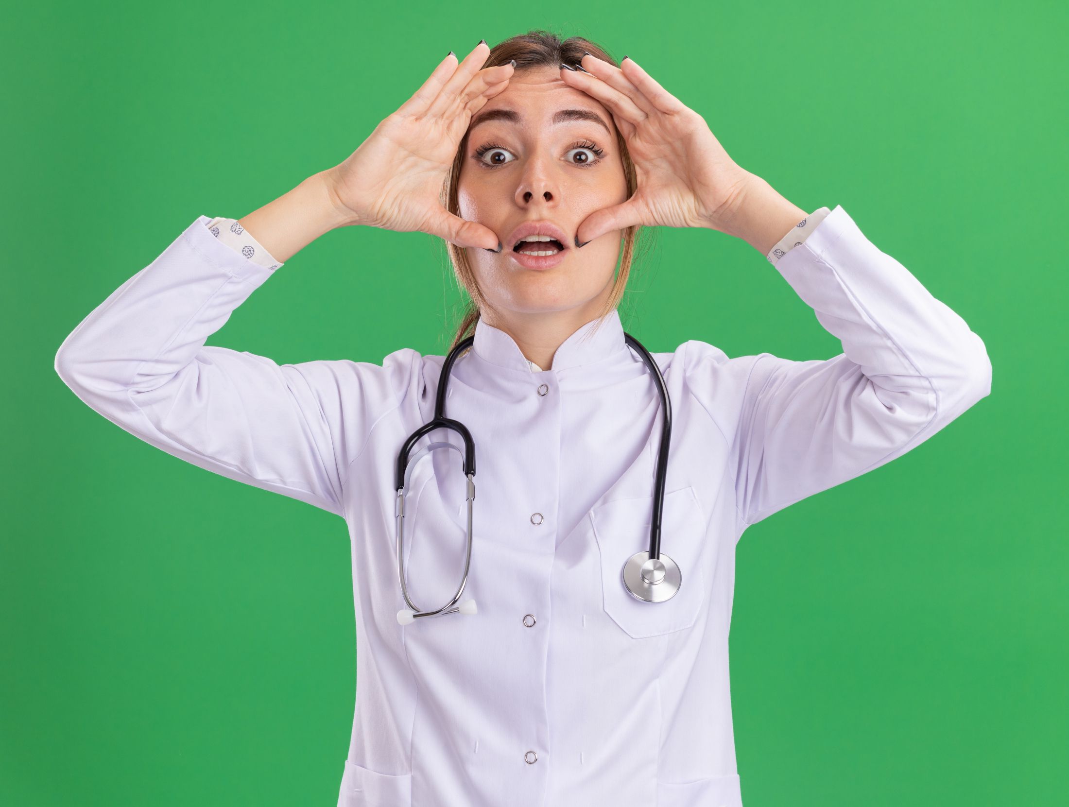 surprised-young-female-doctor-wearing-medical-robe-with-stethoscope-putting-hands-around-eyes-isolated-on-green-wall.jpg