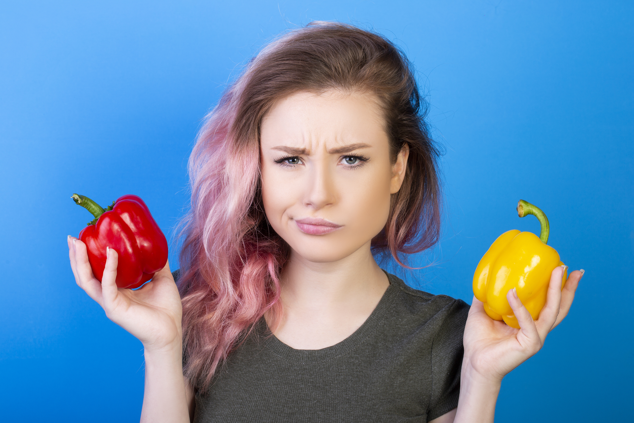 puzzled-woman-holding-red-and-yellow-peppers-in-different-hands.jpg