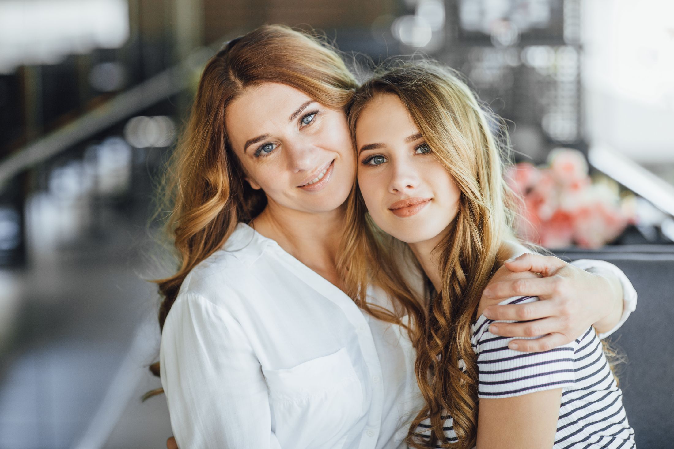 mom-and-young-beautiful-teenage-daughter-hug-on-a-summer-terrace-cafe-in-casual-clothing.jpg