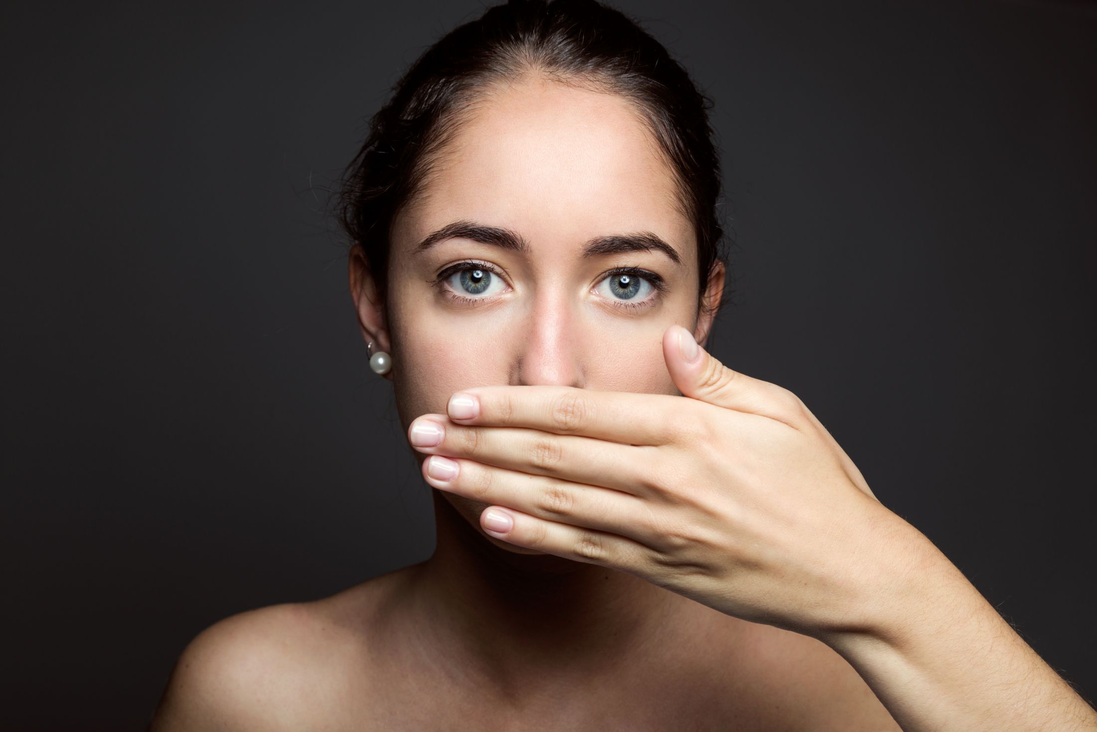 beautiful-young-woman-covering-her-mouth-with-hand-isolated.jpg