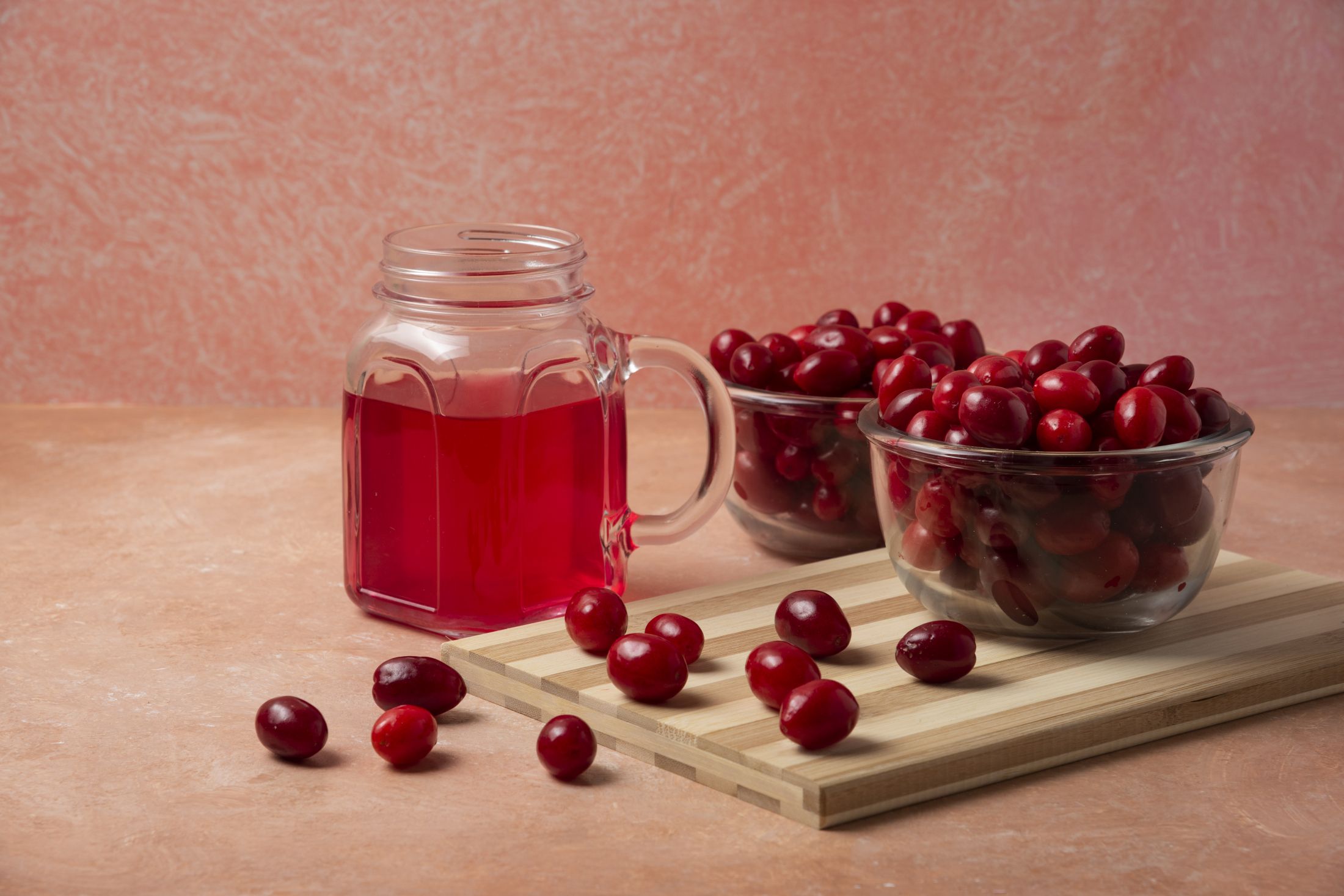 cornels-in-glass-cup-and-juice-in-a-jar-on-a-pink-background.jpg