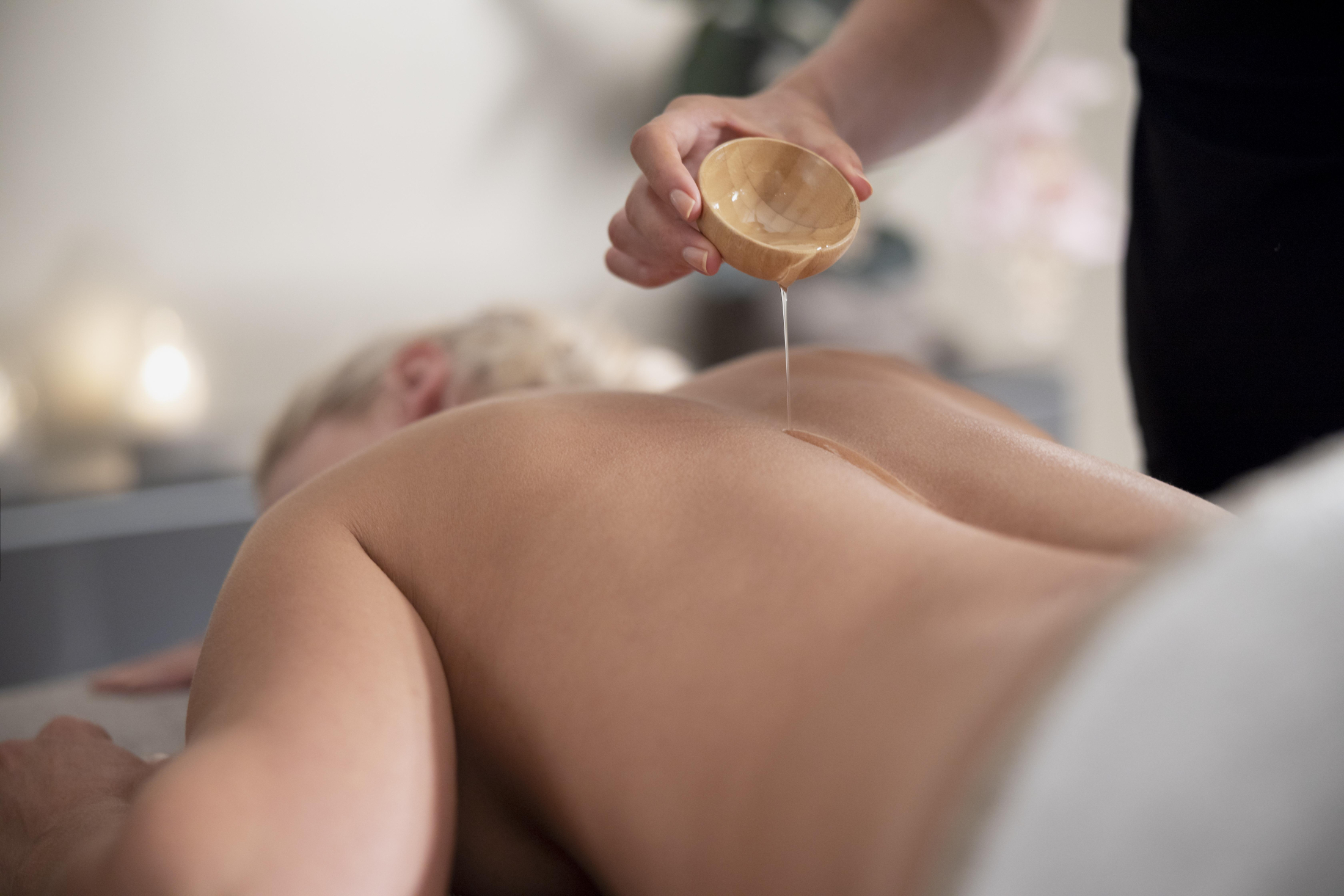 young-woman-using-massage-oil-her-client.jpg