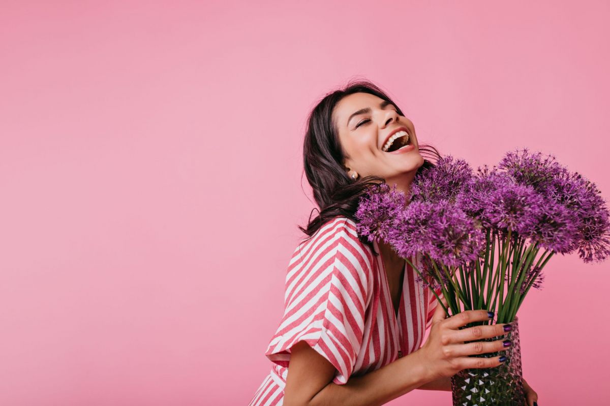 girl-in-pink-sundress-enjoys-scent-of-flowers-and-sincerely-laughs-enjoying-great-spring-day.jpg