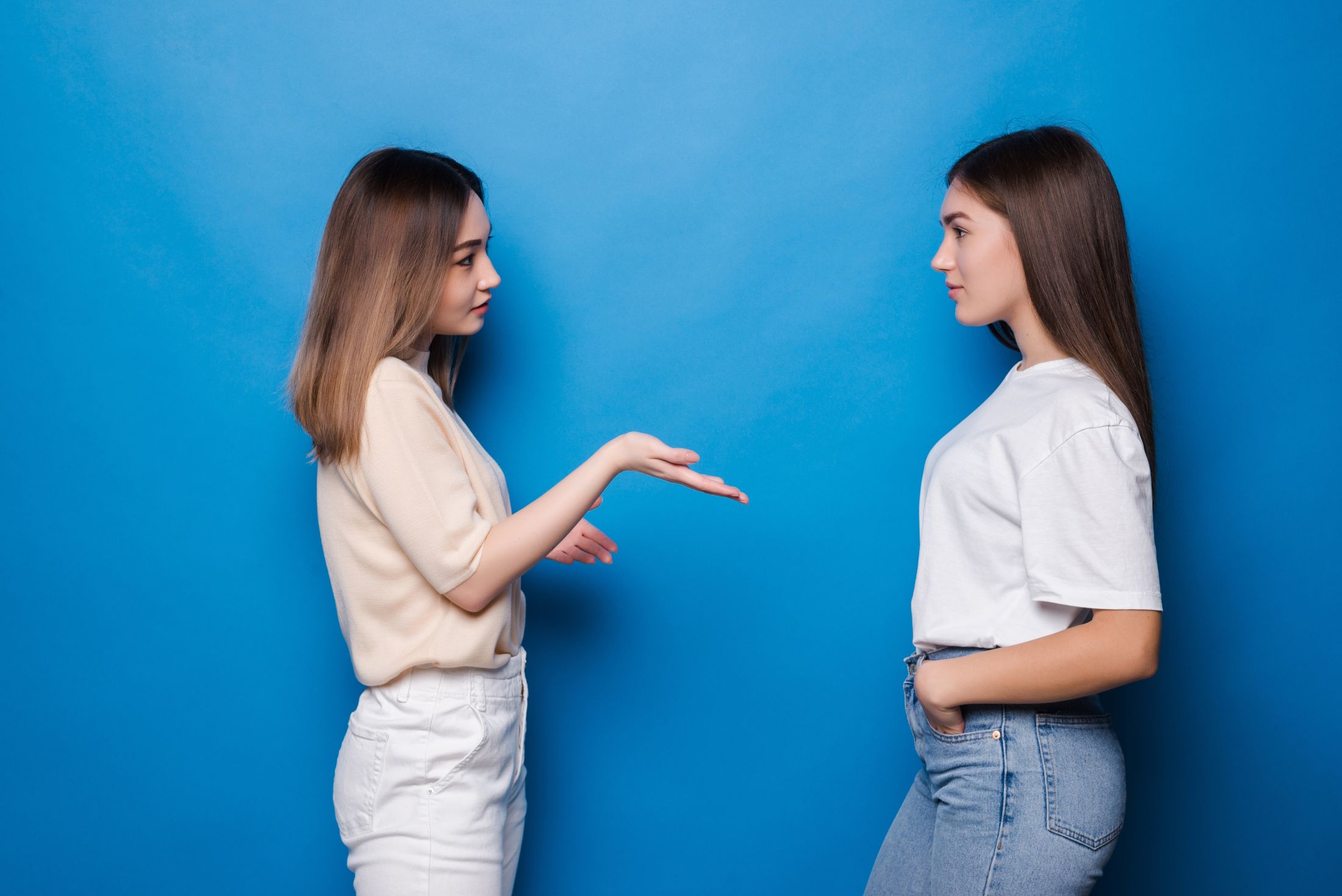 portrait-of-girls-talking-spending-time-isolated-on-blue-wall.jpg
