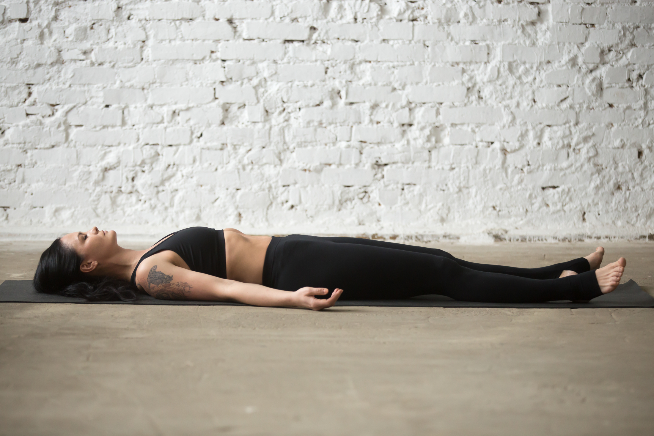 young-yogi-attractive-woman-savasana-pose-white-loft-backgro.jpg