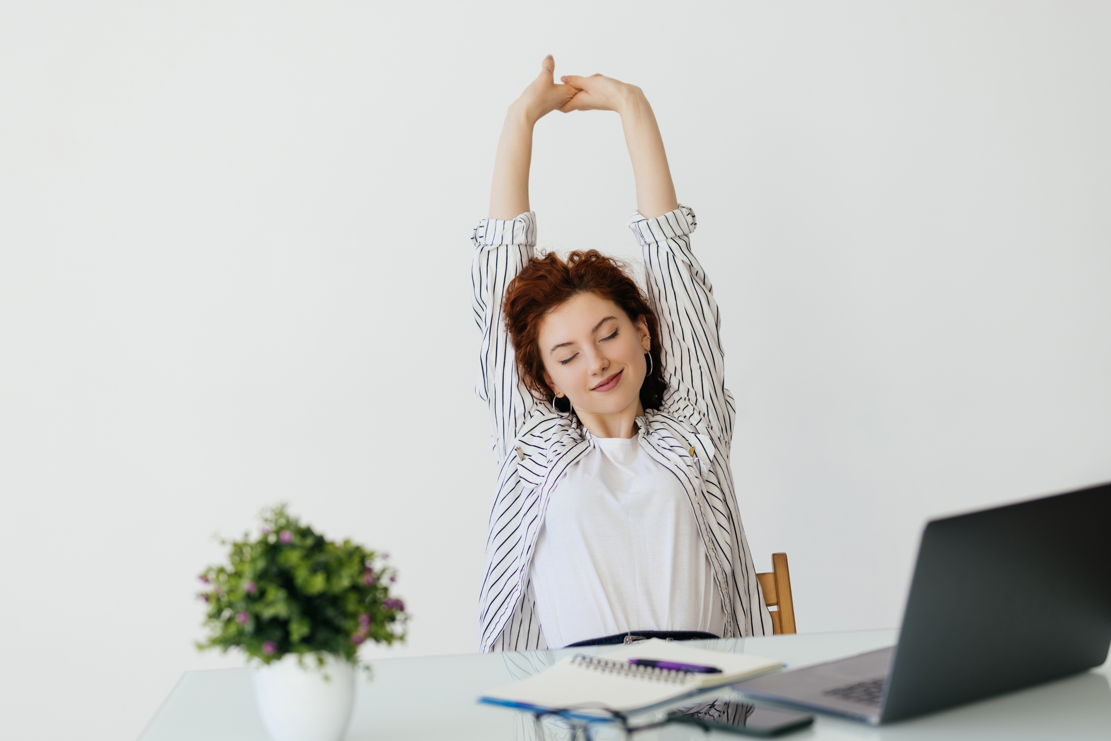 young-redhead-woman-working-with-her-laptop-stretching-arms-relaxed-position.jpg