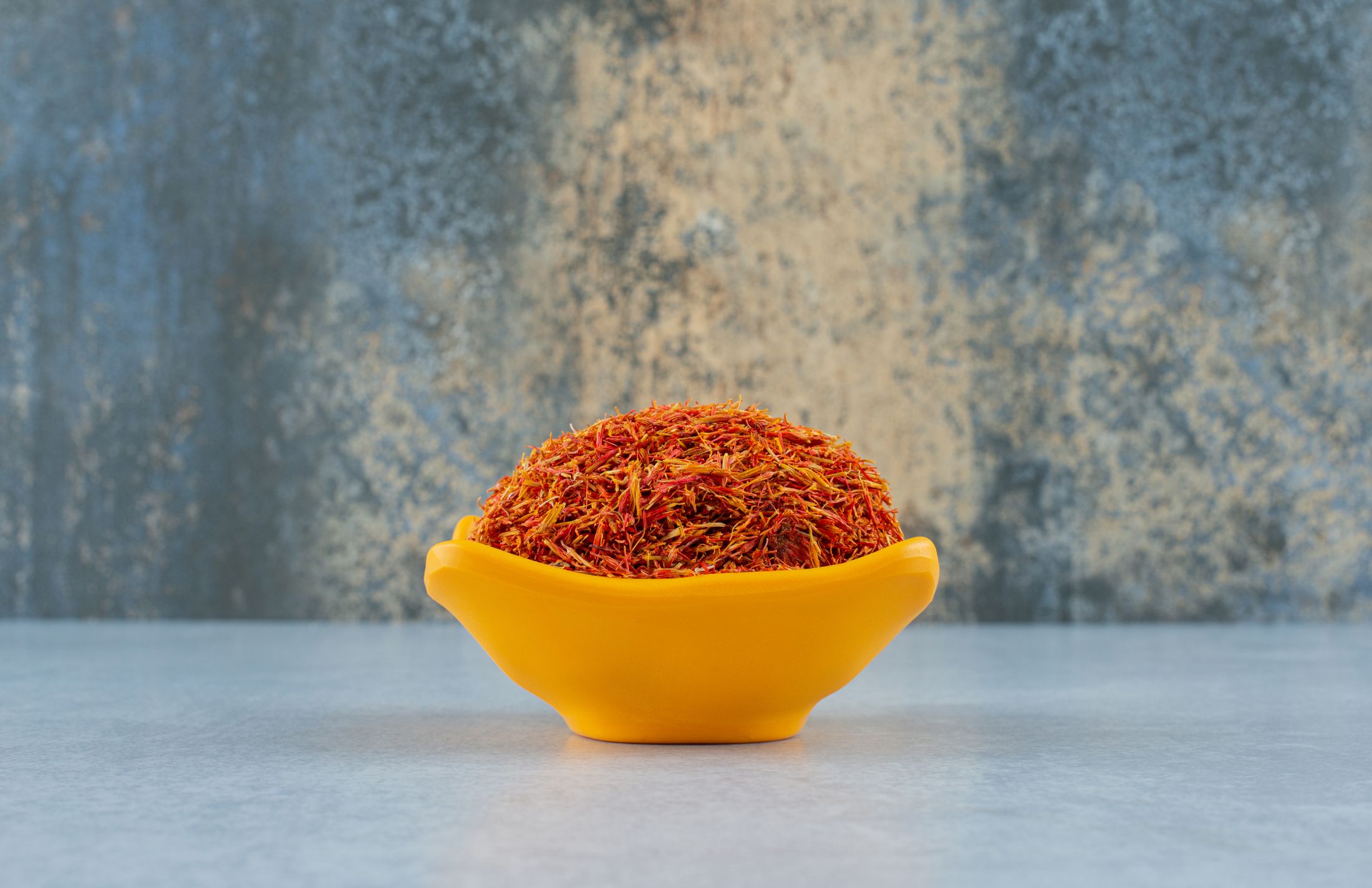 saffron-spices-in-a-yellow-ceramic-cup-on-blue-background-high-quality-photo.jpg