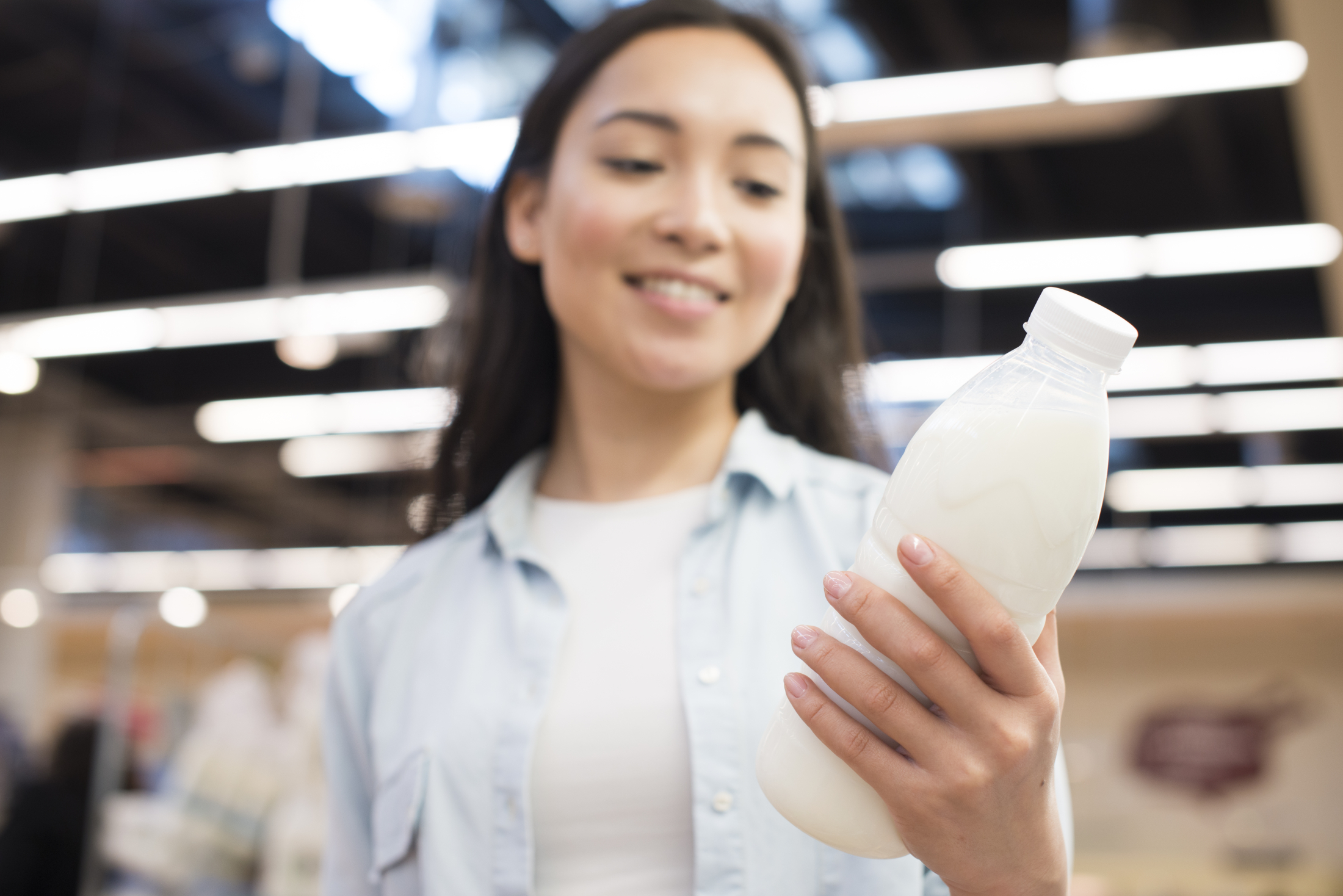cheerful-asian-female-holding-bottle-milk-supermarket.jpg